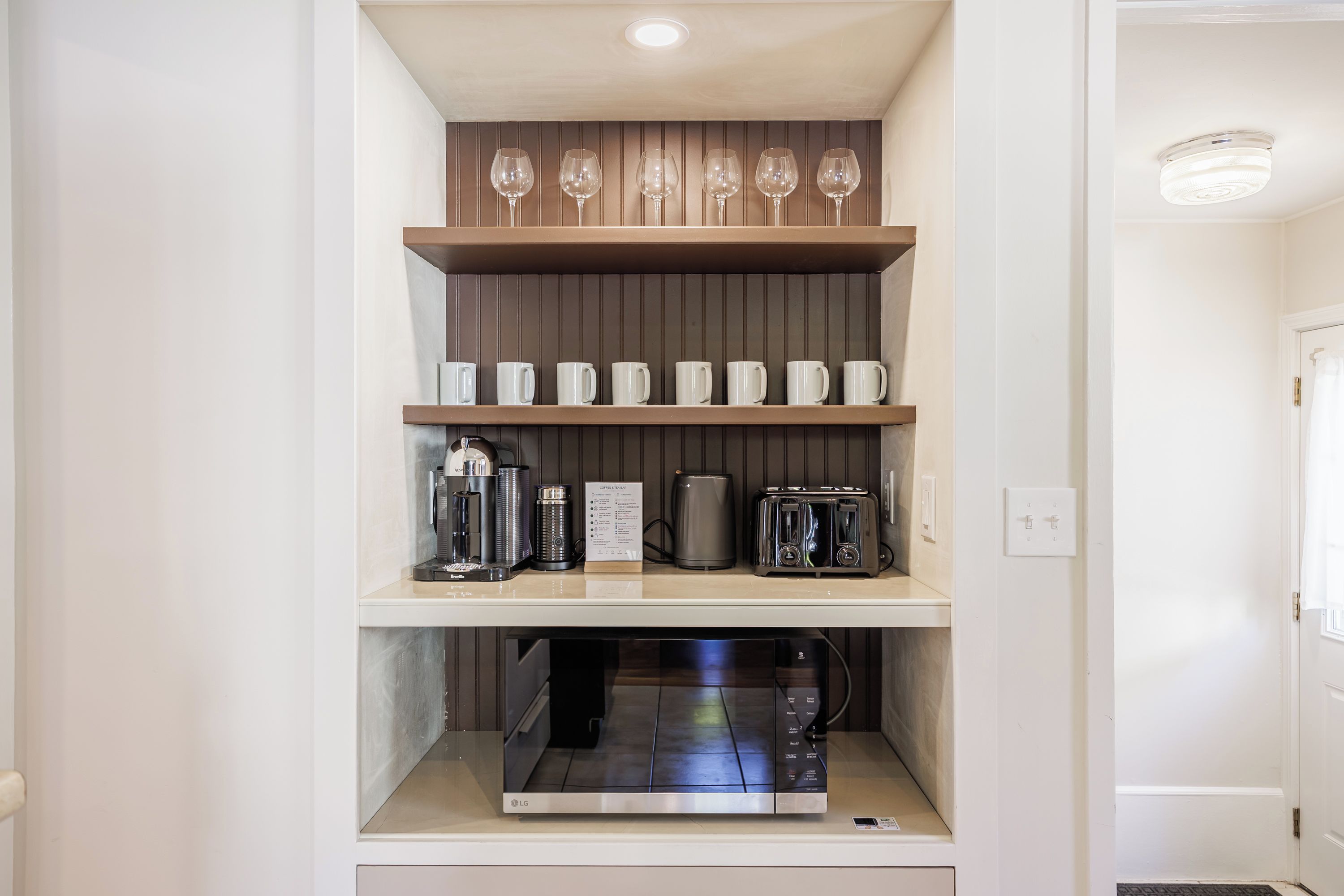 Una cocina equipada con microondas, cafetera y tostadora.