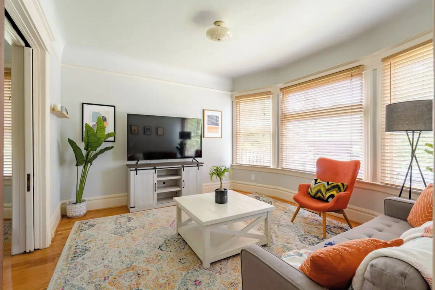A living room with a television, a sofa, a coffee table, and a chair.