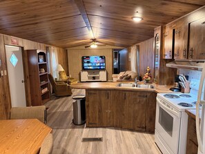 Una cocina compacta con una isla central, horno empotrado y estufa.