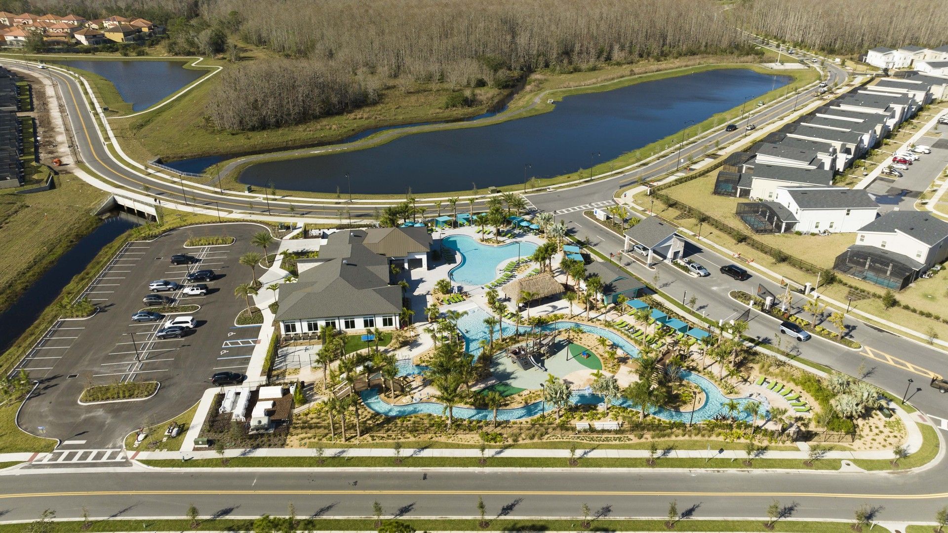 A residential area with a swimming pool, parking, and a road.