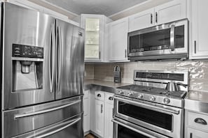 A modern kitchen with stainless steel appliances including a refrigerator, microwave, stove, and oven. - Lakefront~Prvt Island~Arcades~Foosball~Pool Table~Ntl Forest~Kayaks~Canoes (Mesick)