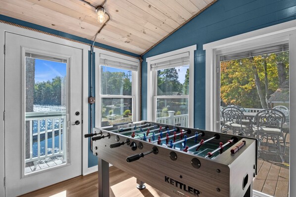 A foosball table in a room with large windows and a view of the outdoors.