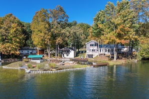 A lakeside property with multiple houses, a dock, and a small boat.