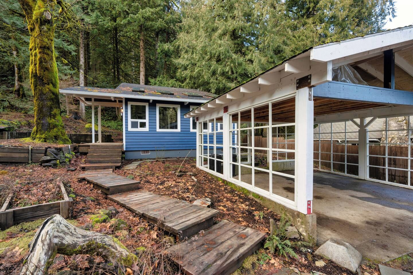 Ein blaues Haus mit verdeckter Veranda und einer Holzterrasse.