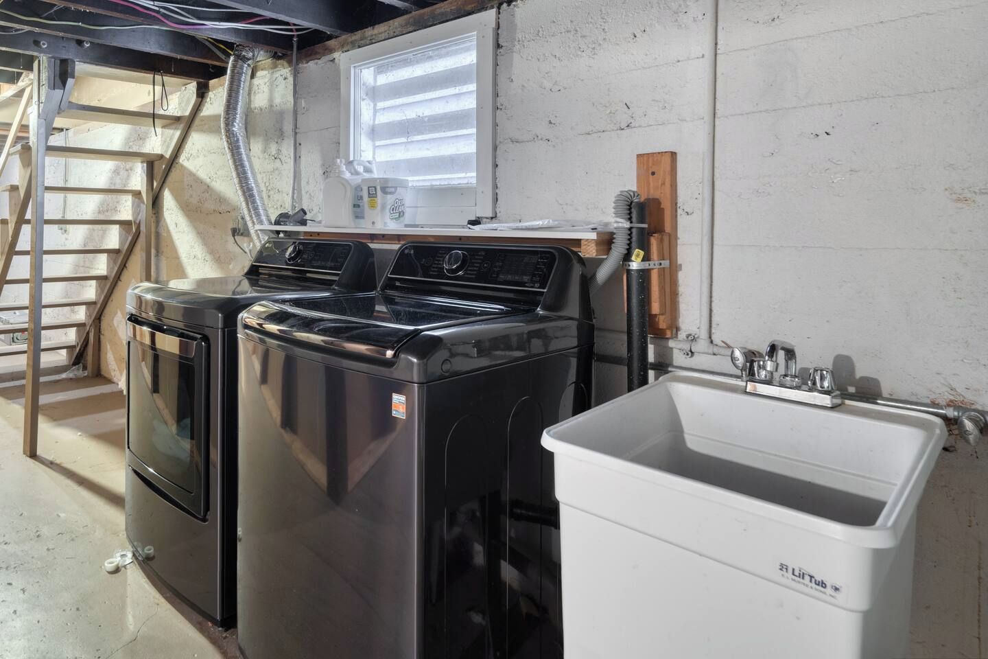 Une buanderie équipée de deux machines à laver et d’un grand évier.