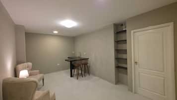 Una habitación con una mesa de comedor, sillas, una puerta blanca y una estantería empotrada.