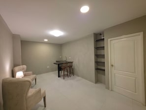 Una habitación con una mesa de comedor, sillas, una puerta blanca y una estantería empotrada.