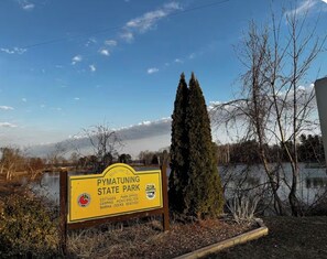 Welkomstbord voor Pymatuning State Park met vermelde faciliteiten zoals vakantiehuisjes, parkkantoor, picknickoverkapping, camping, jachthaven en steigers.