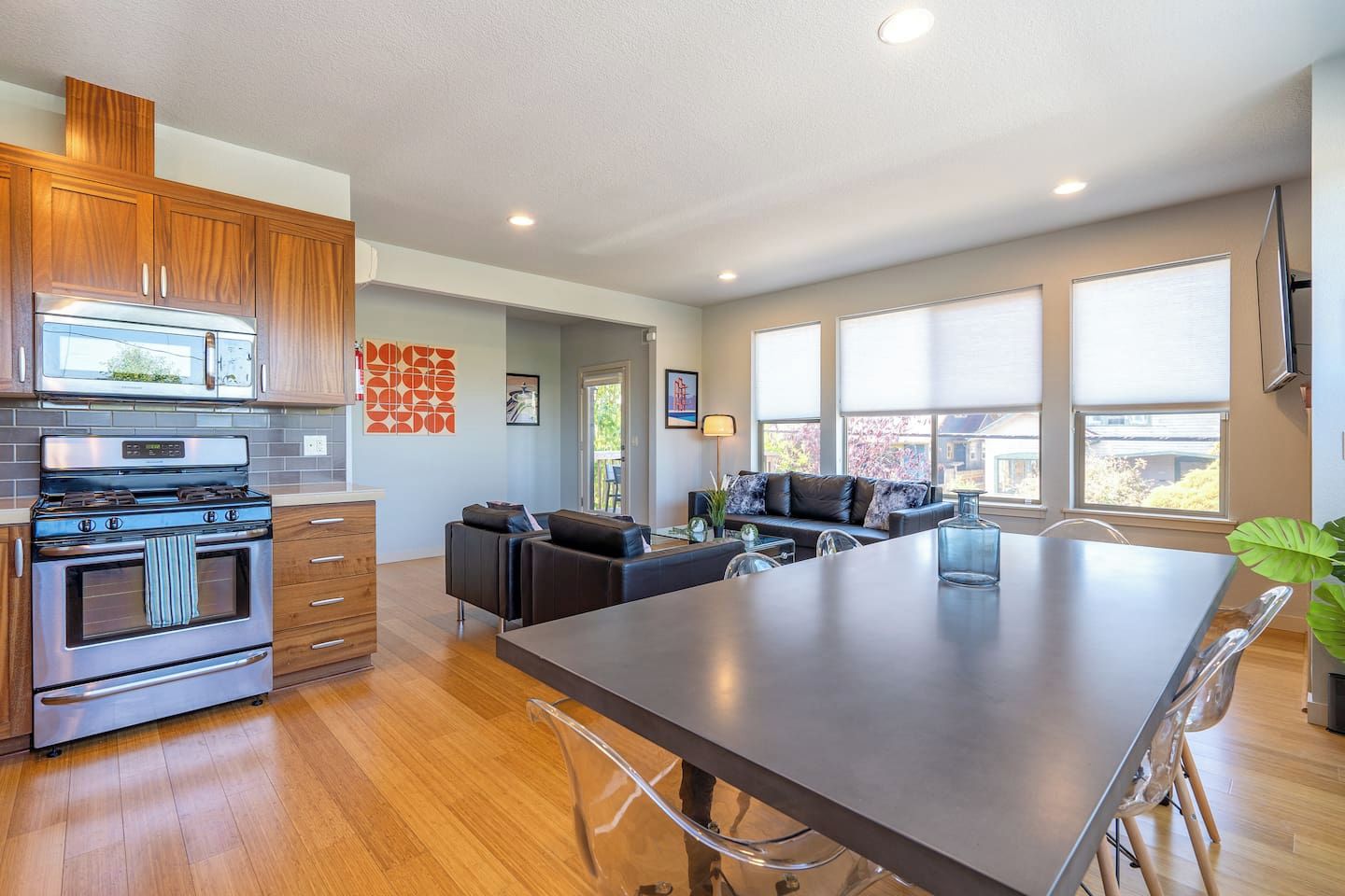 A modern kitchen with built-in appliances, a dining area with a large table, and a seating arrangement.