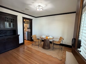 A dining area with a round table, four chairs, and a rug. - The Surfperch Cottage, Private Garage and Patio (Hermosa Beach)