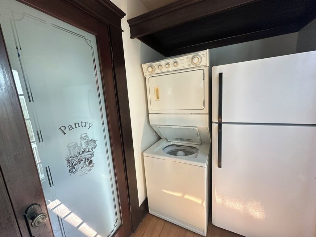 A compact kitchen with a white refrigerator, a washing machine, and a stove.