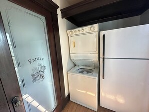 A compact kitchen with a white refrigerator, a washing machine, and a stove. - The Surfperch Cottage, Private Garage and Patio (Hermosa Beach)