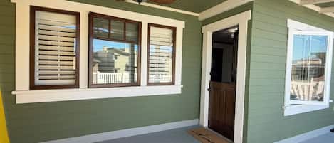 A covered porch with a ceiling fan, a welcome mat, and a door leading to a garage.