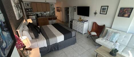 A modern bedroom with a bed, bedside table, and a desk area with a chair.