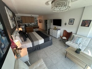 Een moderne slaapkamer met een bed, nachtkastje en een bureau met een stoel.