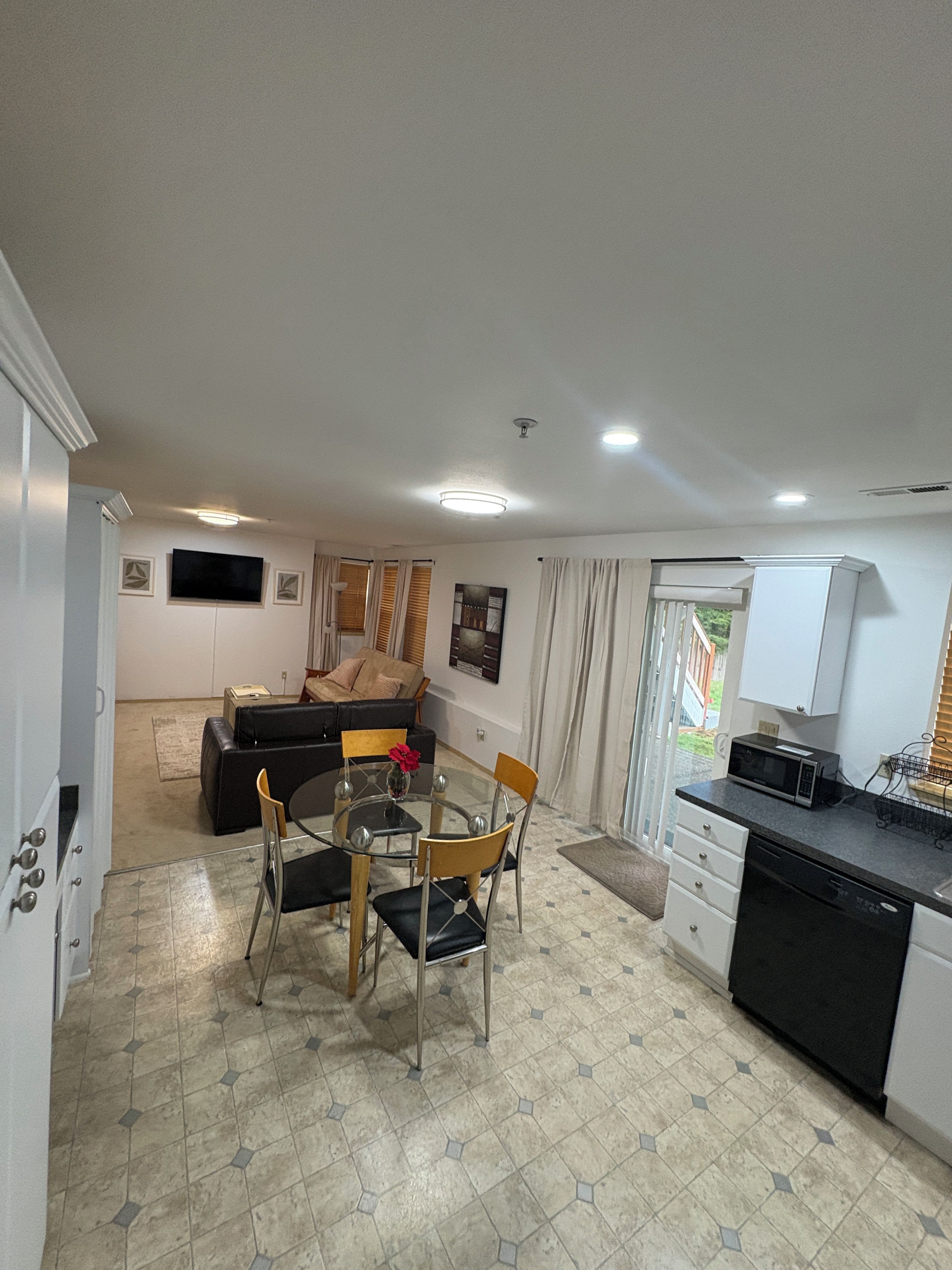 Un espacio habitable funcional con comedor, kitchenette y sofá al fondo.