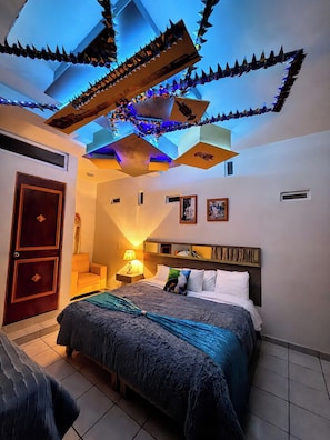 Un dormitorio moderno con cama, mesita de noche, lámpara y decoración en el techo.