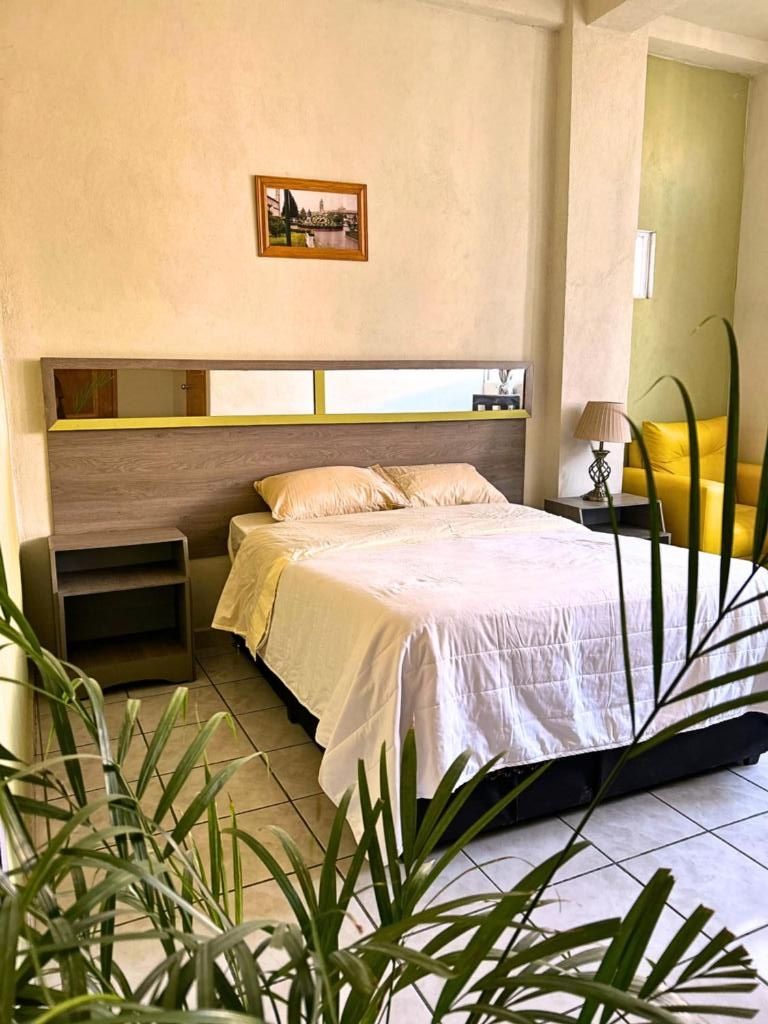 Una camera da letto con un letto, un comodino e una mensola a parete.