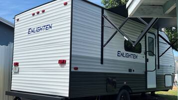 Una caravana estacionada con el nombre de marca 'ENLIGHTEN' en la carrocería.