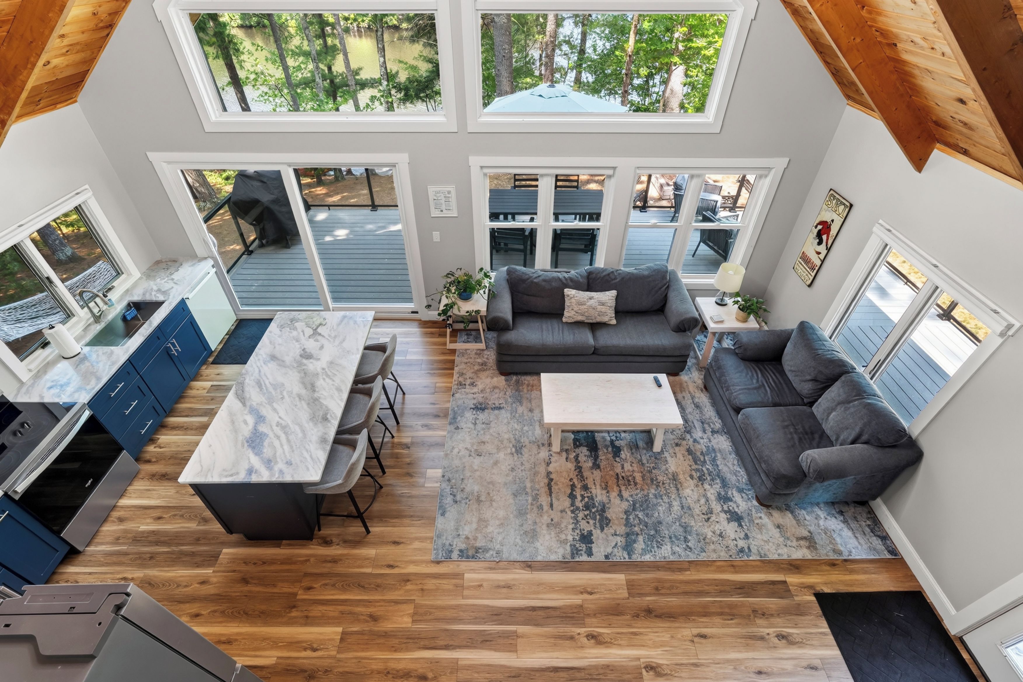 A spacious living area with a kitchen, dining area, and a view of the outdoors through large windows.