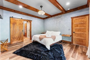 Una camera da letto con un letto, un'armadio in legno e una ventola a soffitto.
