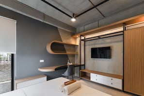 A modern bedroom with a bed, a desk, and built-in storage. - Cove Indrakila (Kota Jakarta Selatan)