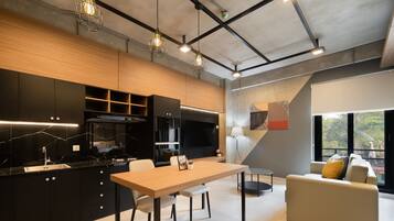 Une cuisine moderne avec un coin repas, des appareils électroménagers intégrés et une grande fenêtre donnant sur un paysage verdoyant.
