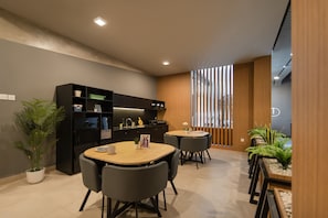 A modern kitchen with a dining area, featuring a black cabinet, a round table, and chairs. - Cove Indrakila (Kota Jakarta Selatan)