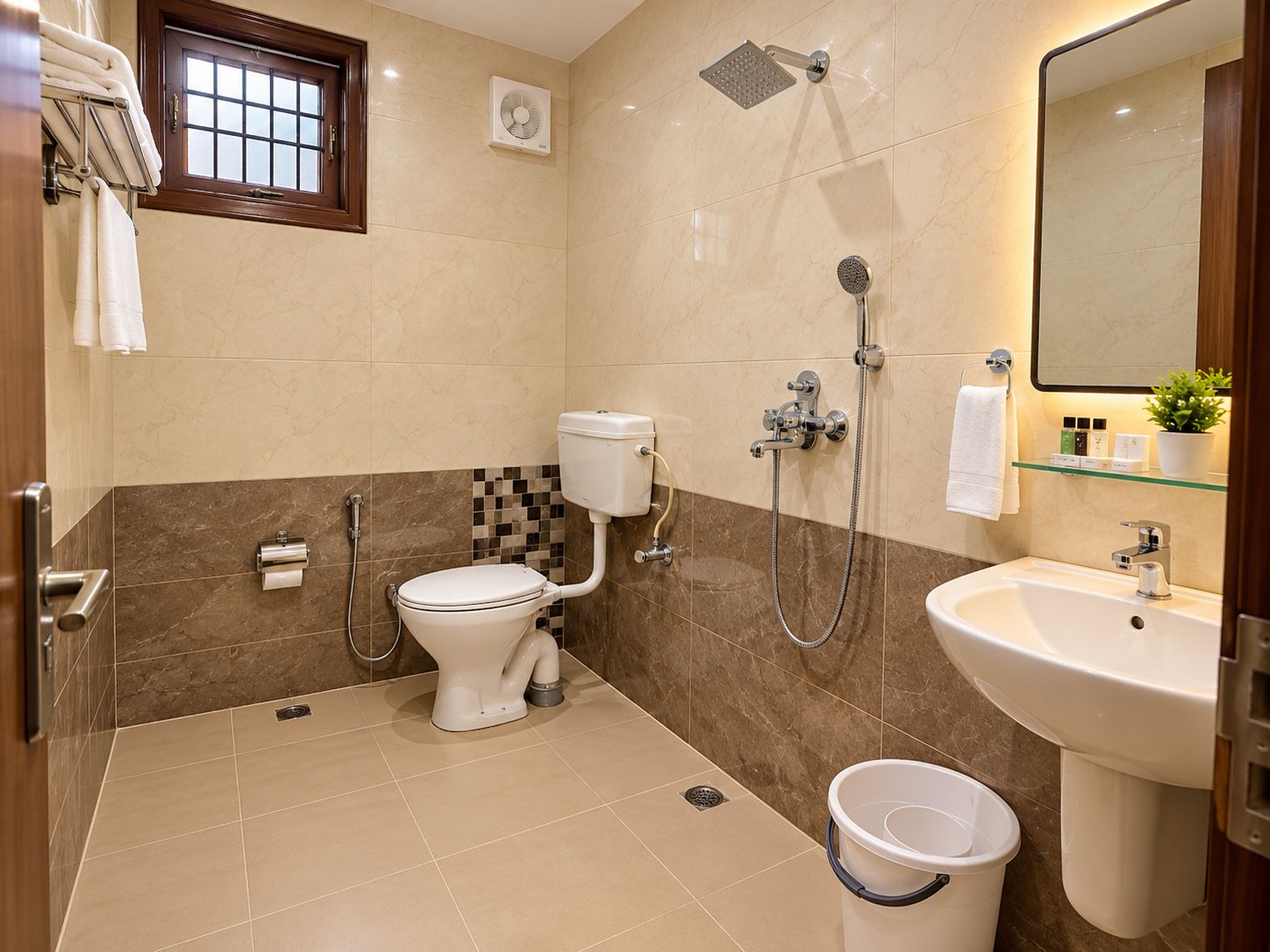 Une salle de bain avec des toilettes, une douche, un lavabo et une petite fenêtre.