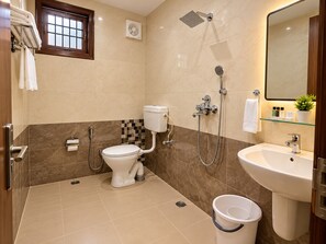 Ein Badezimmer mit Toilette, Dusche, Waschbecken und einem kleinen Fenster.