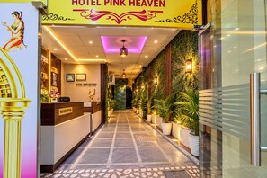 Ein Hotel-Empfangsbereich mit einer Rezeption, einem an der Wand befestigten Schild und einem zur Innenausstattung führenden Gang.