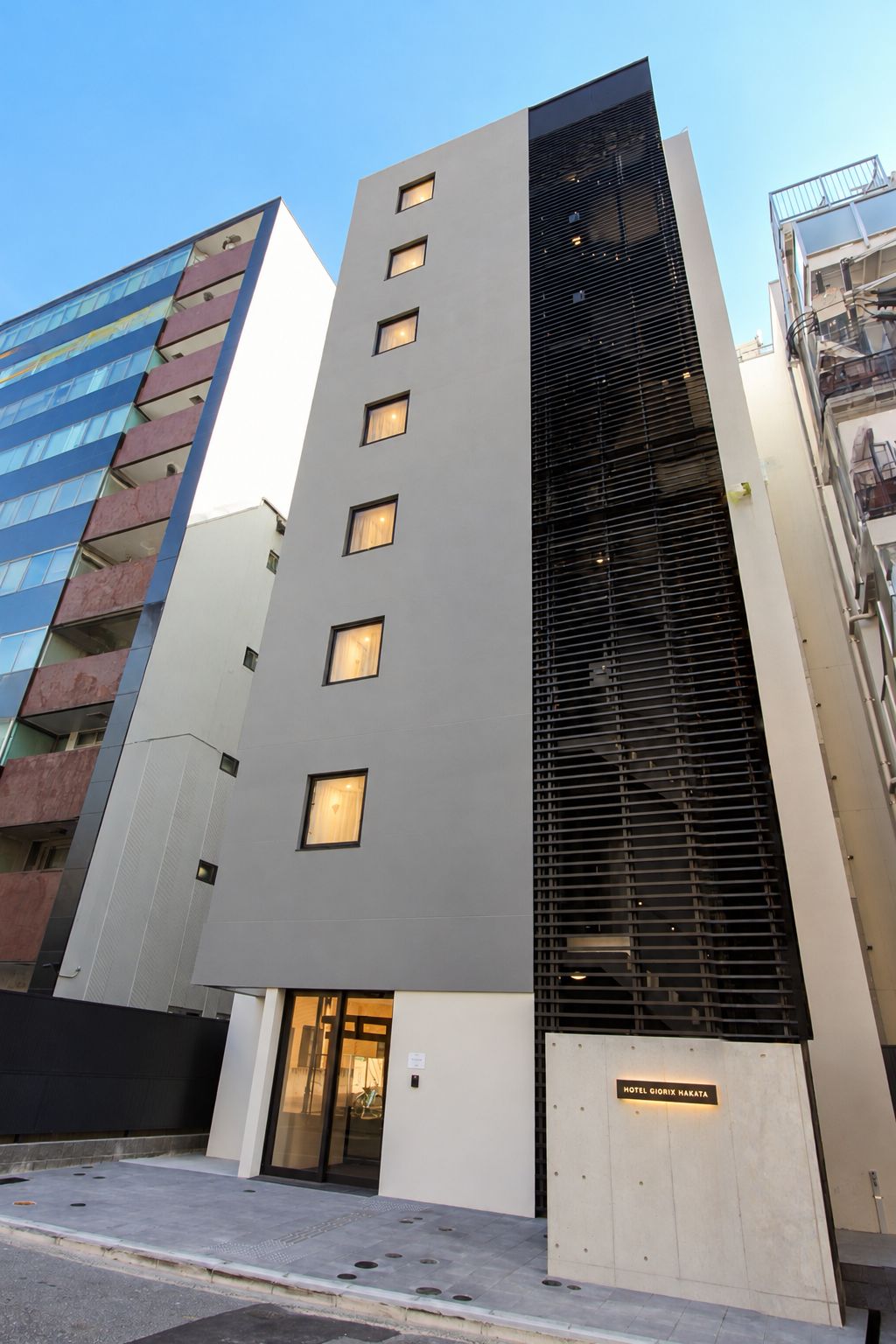 Un edifici d'hotel modern amb una entrada destacada, múltiples finestres i un cartell amb el nom 'HOTEL GIORGI MARATA'.