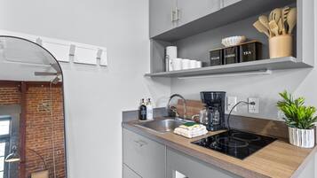 Een moderne keuken met een inbouwvaatwasser, een koffiezetapparaat en een plant op het aanrecht.