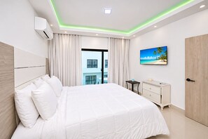 Una camera d'albergo moderna con un letto grande, una scrivania e vista su un edificio.