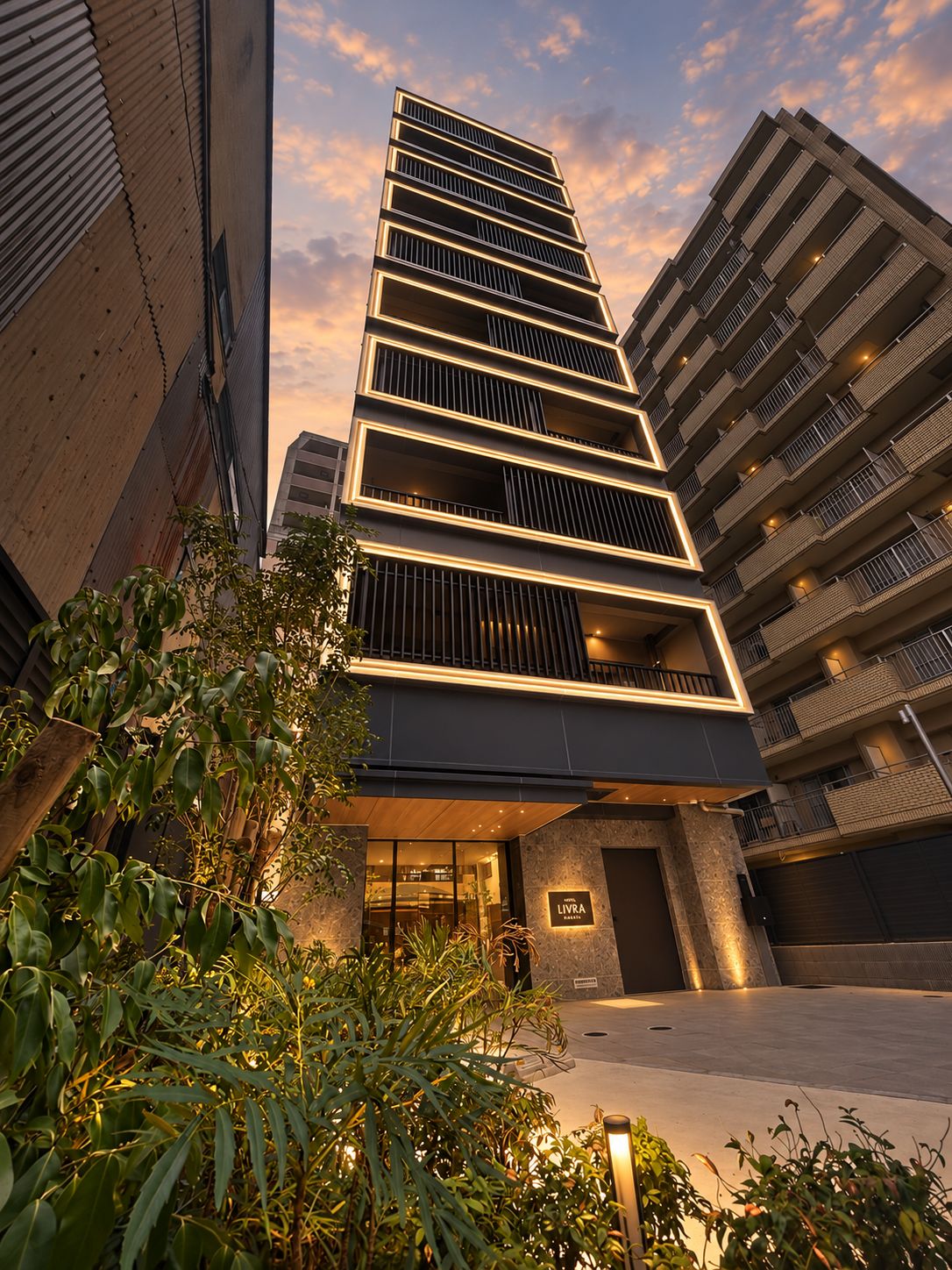 A modern hotel building with multiple floors, a prominent entrance, and a sign indicating it is a hotel.