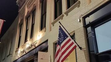 Een gebouw met een etalage waarop 'EATY BARRELS COFFEE' staat en een Amerikaanse vlag.