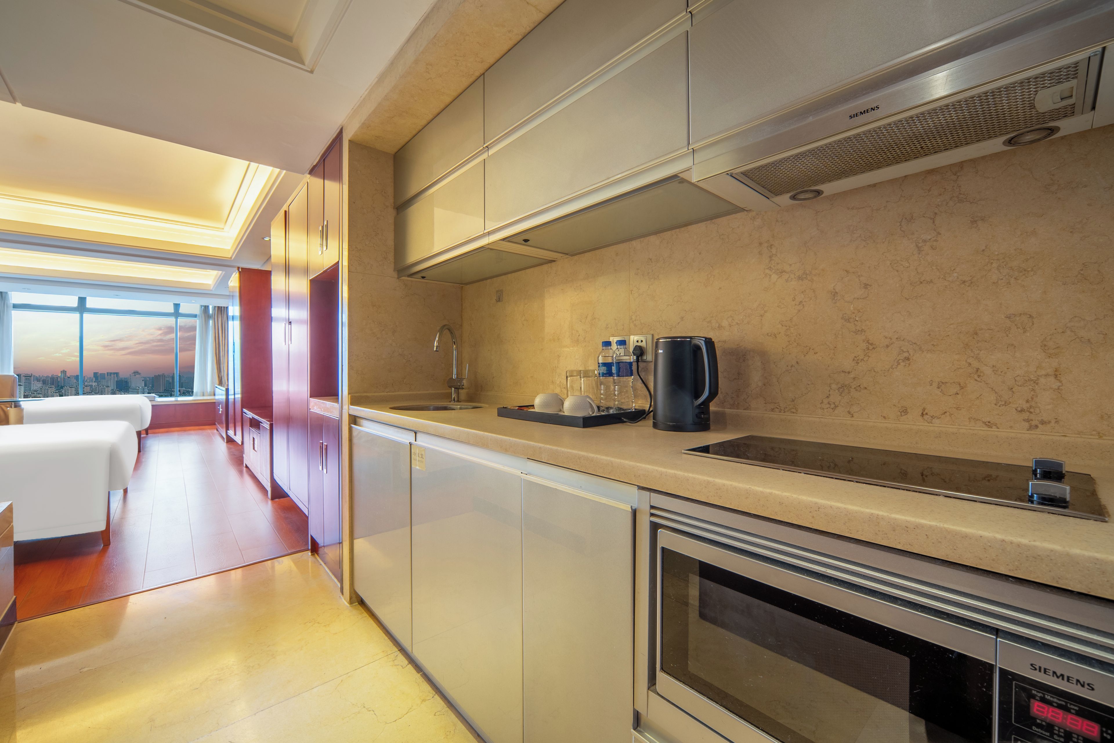 Eine moderne Küche mit Backofen, Kaffeemaschine und Blick auf die Stadt.