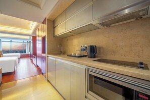 A modern kitchen with a built-in oven, a coffee maker, and a view of the city. - EAC Oakmade Residence Hangzhou (Hangzhou)