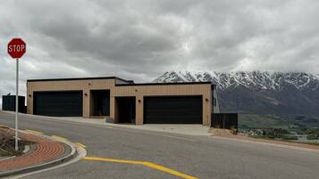 A building with two garage doors, a stop sign, and a mountainous landscape in the background.