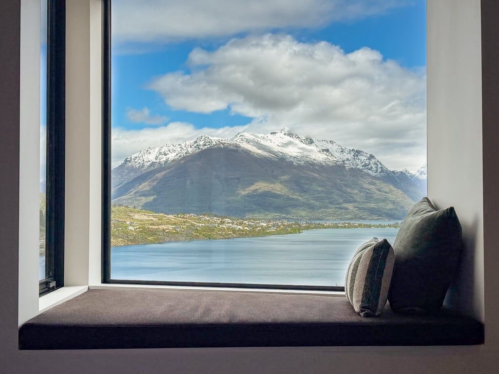 A window seat with a view of a mountain and a lake.