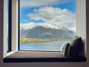 A window seat with a view of a mountain and a lake. - Elevated Remarkables Vista | Sweeping Lake Views (Queenstown)
