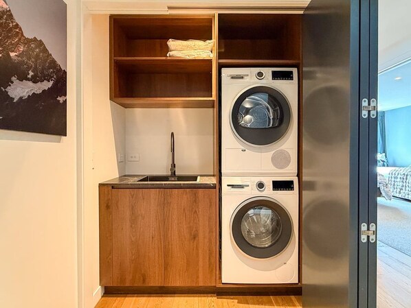 Enjoy the convenience of a dedicated laundry area with a washing machine, dryer and sink. - Elevated Remarkables Vista | Sweeping Lake Views (Queenstown)