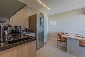 Eine moderne Küche mit Einbauherd, Kaffeemaschine und einem großen Kühlschrank.