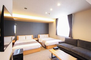 A hotel room with two beds, a sofa, a TV, and a desk with a computer. - Nagasaki Base Sanno (Nagasaki)