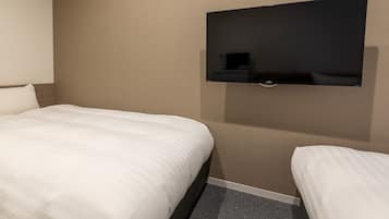 A hotel room with a bed, a small bedside table, and a wall-mounted television.
