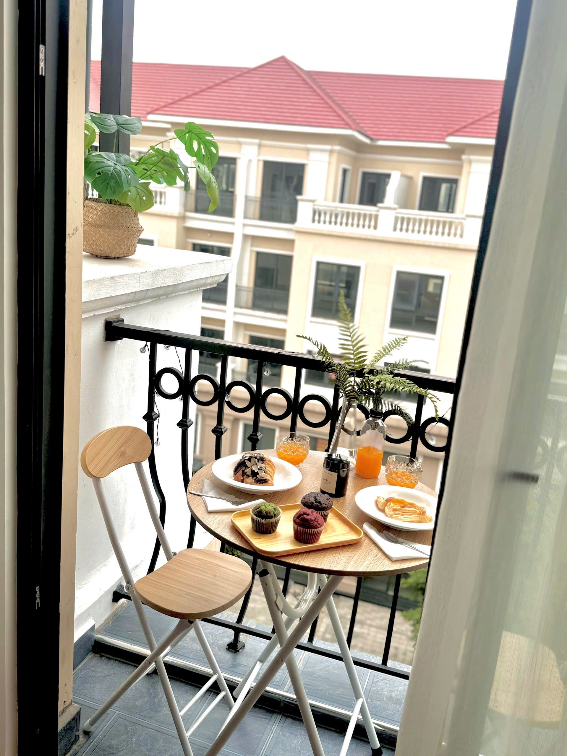 Ein Balkon mit Esstisch, Stühlen und einem Blumentopf.