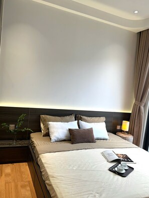 Ein Hotelzimmer mit Bett, Nachttisch, Lampe und einem Tablett mit Tassen.