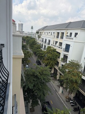 Ein mehrstöckiges Wohngebäude mit Balkonen, einem Straßenblick und einem Baukran im Hintergrund.