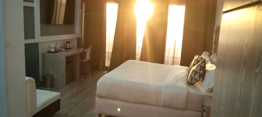 Una habitación de hotel con una cama, un escritorio y una silla.