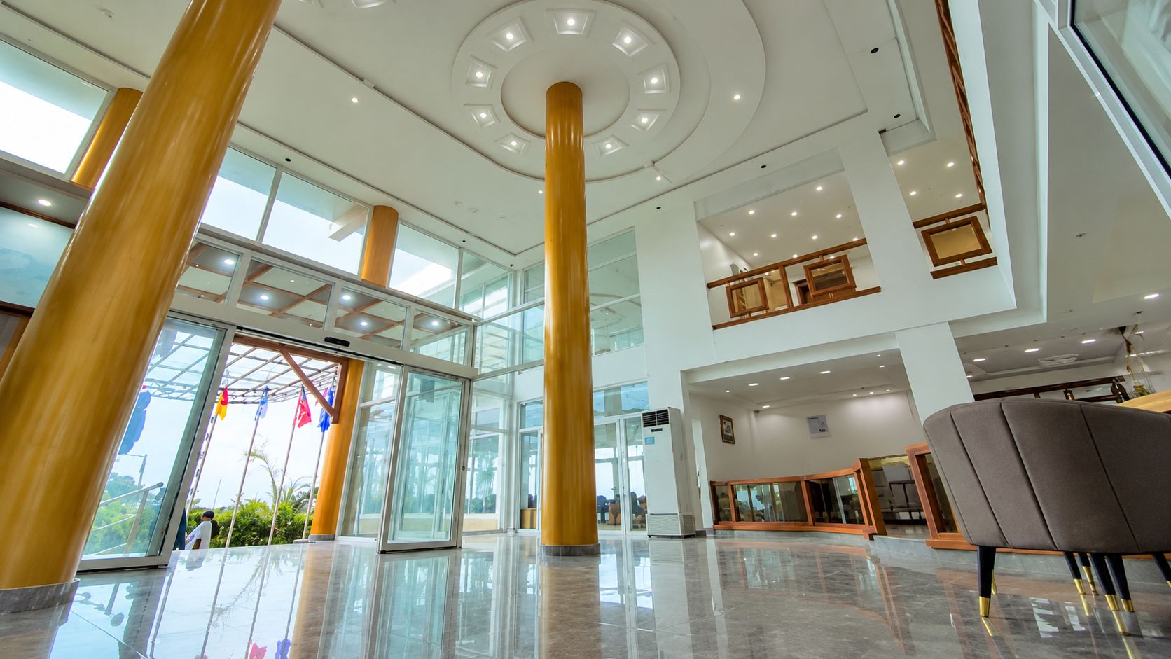Un hall d’entrée spacieux, doté de hauts plafonds, de grandes portes vitrées et d’un design moderne.